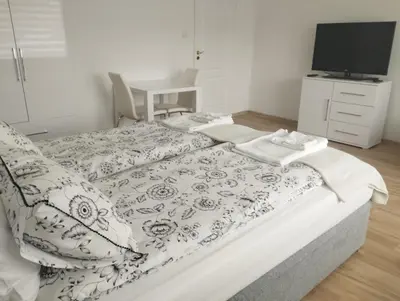 a white bedroom with a bed and a window at Apartament przy 29 alei in Kraków