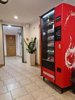 a red drink vending machine in a hallway at Amber Hostel in Kraków
