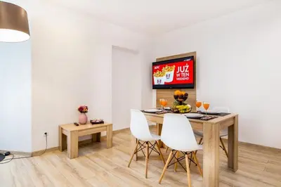 a dining room with a table and white chairs at Bosacka old town apt - B17 in Kraków