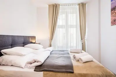 a bedroom with a large bed with white sheets and pillows at Bosacka old town apartment - B28 in Kraków