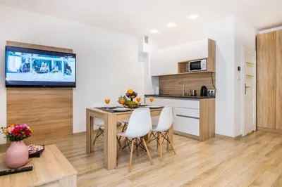 a kitchen with a table and chairs and a television at Bosacka old town apartment - B28 in Kraków