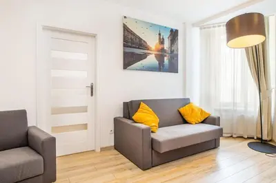 a living room with a couch and a chair at Bosacka old town apartment - B28 in Kraków