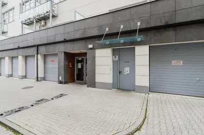 a row of garage doors on a building at Turquoise Studio with Balcony & Air Conditioning Kraków by Noclegi Renters in Kraków