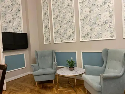 a living room with two chairs and a table and a tv at Radiance Residence Apartments in Kraków