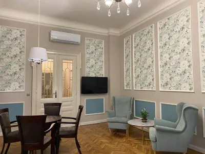 a living room with chairs and a table and a tv at Radiance Residence Apartments in Kraków