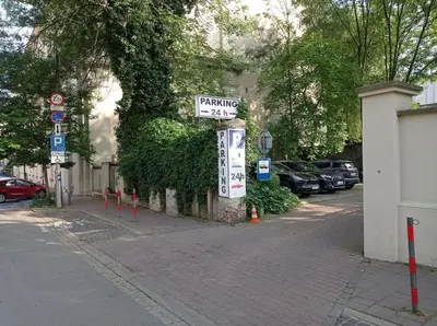 a row of cars parked on the side of a street at A cozy apartment in the heart of the city in Kraków