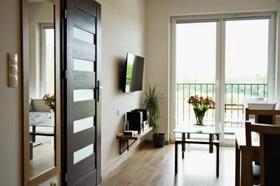 a living room with a door and a table with a television at Apartamenty Galicja Zator by Housine in Zator