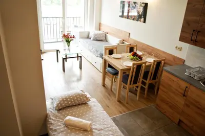 a small apartment with a bed and a table and a kitchen at Apartamenty Galicja Zator by Housine in Zator