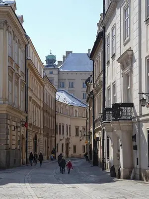 a group of people walking down a street with buildings at Cracow Fancy Brick #4 - Old Town in Kraków
