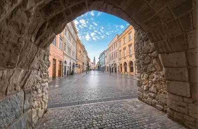an archway in a city with a cobblestone street at Cracow Copernican Apartment #1 - Old Town in Kraków