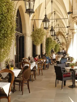 a restaurant with tables and chairs and people sitting at tables at Cracow Copernican Apartment #2 - Old Town in Kraków