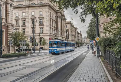 a blue bus driving down a city street at Cracow Route #1 - Old Town in Kraków