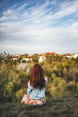a little girl sitting in a field looking at the horizon at Cracow Route #3 - Old Town in Kraków