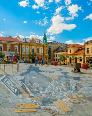 a mural in a square in a city with buildings at Cracow Vistula Boulevard #3 - Old Town in Kraków