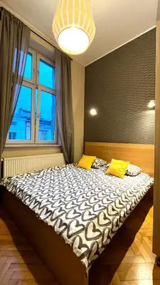 a large bed in a room with a large window at City Center Studio in Kraków