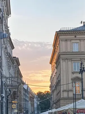 a city street with buildings and a sunset in the background at Cracow Fancy Brick #2 - Old Town in Kraków