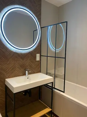 a bathroom with a sink and a mirror at Leo Apartments Kraków in Kraków