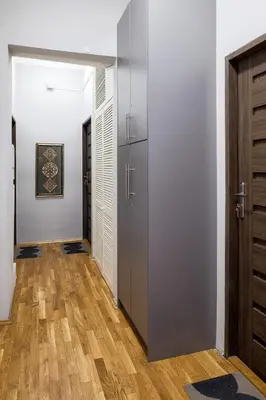a hallway with two doors and a wooden floor at Mint&Jade studio A in Kraków