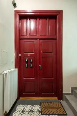 a red door in a room with a staircase at Mint&Jade studio B in Kraków