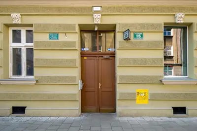 a yellow building with a brown door and windows at Mint&Jade studio D in Kraków