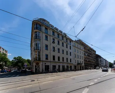 a large white building on the side of a street at Cozy studio - Starowislna 54 Street in Kraków