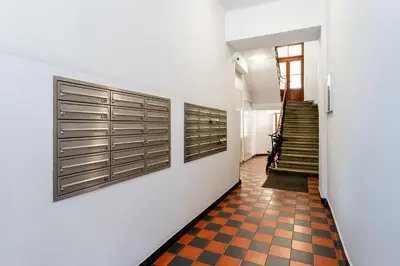 a hallway with white walls and a checkered floor at Cozy Studio - Starowislna 54 in Kraków