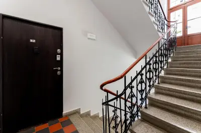a set of stairs with a black door and a black railing at Cozy Studio - Starowislna 54 in Kraków