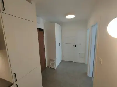 an empty hallway with a door and a stool at 2-Bedroom Apartment with 2 Free Parking Spots - TAURON ARENA in Kraków