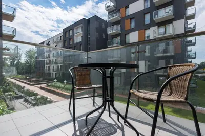 a table and two chairs on a balcony with a view at NEARTOpl Rakowicka Family apartments in Kraków