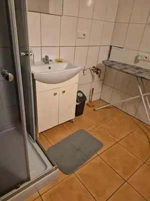 a small bathroom with a sink and a shower at Pokoj u Eleni #2 in Kraków