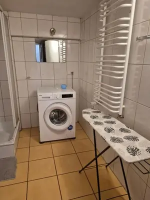 a small bathroom with a washing machine and a table at Pokoj u Eleni #1 in Kraków