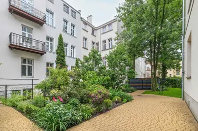 a courtyard with a garden in front of a building at Charming Apartments with Desk in Downtown Cracow by Noclegi Renters in Kraków