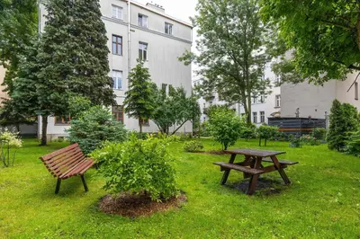 a park with a wooden bench and a picnic table at Charming Apartments with Desk in Downtown Cracow by Noclegi Renters in Kraków