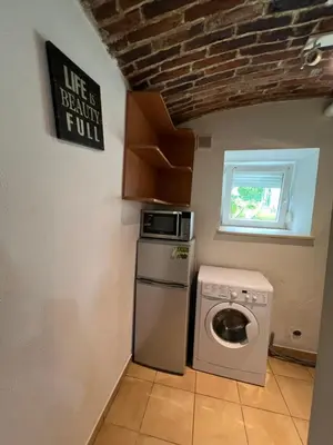 a kitchen with a washing machine and a microwave at Kawalerka-Studio underground in Kraków