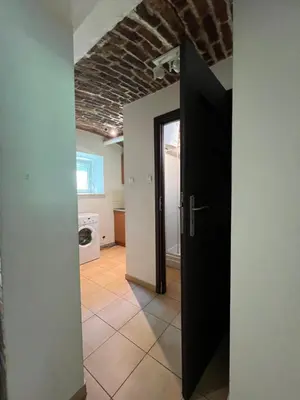 a hallway with a black door and a brick ceiling at Kawalerka,studio underground in Kraków