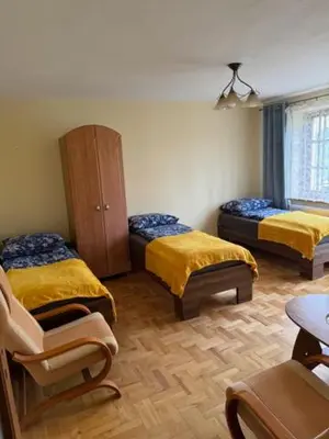 a room with two beds and a cabinet and a chair at Bochnia,kwatery pracownicze,duży dom, noclegi in Bochnia