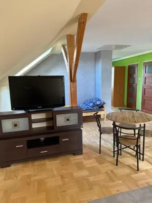 a living room with a flat screen tv and a table at Bochnia,kwatery pracownicze,duży dom, noclegi in Bochnia