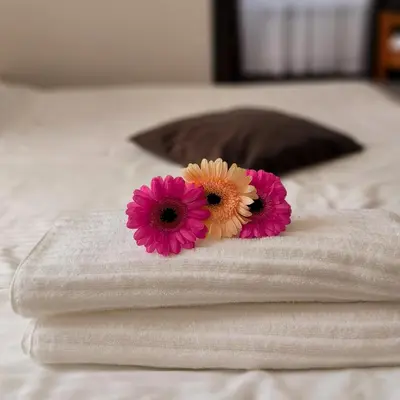 two pink and yellow flowers on top of a bed at Noclegi Pod Lyskami in Nowy Targ