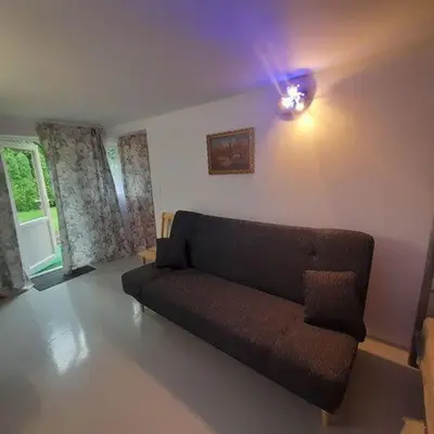 a couch in a living room with a light at Domek Krukk blisko Energylandii Zator in Zator