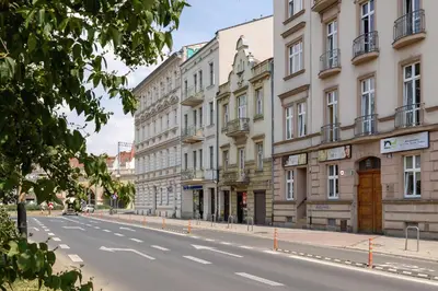 an empty city street with buildings on either side at Stylish Apartment Dietla with Balcony in Kraków by Noclegi Renters in Kraków