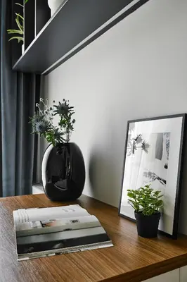 a table with a picture and a vase with plants on it at City Dreams Apartment in Kraków