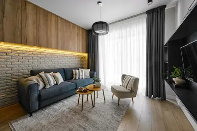 a living room with a blue couch and a brick wall at City Dreams Apartment in Kraków