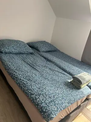 a bed with a blue comforter on top of it at Mieszkanie na Lawendowej in Kraków