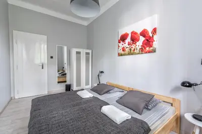 a bedroom with a bed and a painting on the wall at Sereno Apartments in Kraków
