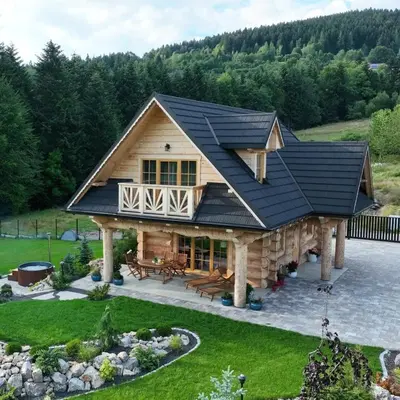 a large log cabin with a black roof at Leśny Zakątek Zawoja in Stryszawa