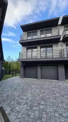 a house with two garage doors and a patio at Apartamenty Żurawia 1 - Piętro 1 in Kraków