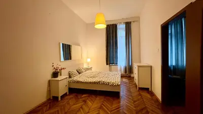 a bedroom with a bed and two windows at Next to Main Square in Kraków