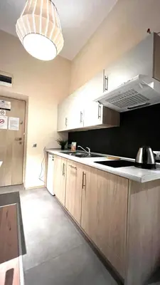 a kitchen with a sink and a stove top oven at Small Studio for 1 in Kraków