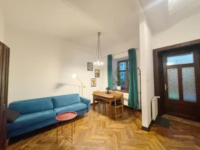 a living room with a blue couch and a table at Batory's Tavern in Kraków