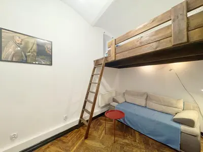 a bedroom with a bunk bed and a ladder at Batory's Tavern in Kraków